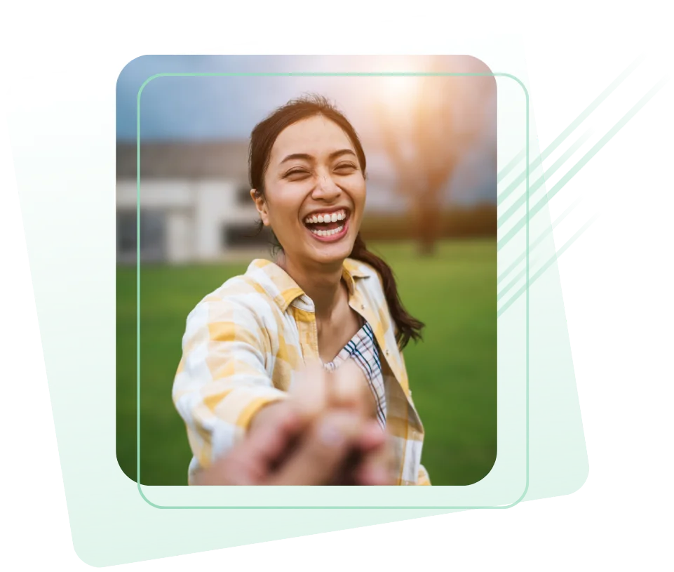 A cheerful young woman in a yellow plaid shirt smiles widely while holding someone’s hand, as if being led forward. She stands outdoors on a green lawn with blurred buildings and trees in the background, framed by a graphic overlay with soft green gradients and diagonal accent lines.