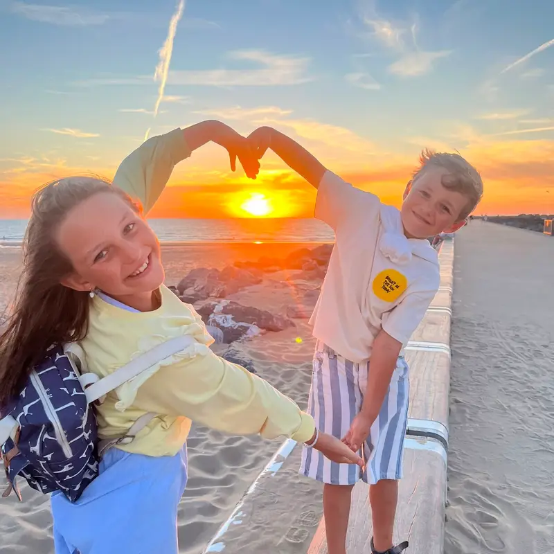 Ellen V.'s photo entry of two kids making a heart shape at sunset